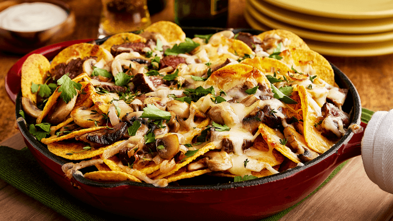 a pan filled with steak nachos garnished with parsley & thyme